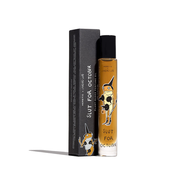 A bottle of 'Slut For October' plant-based perfume oil with a black cap, standing next to its black packaging box.